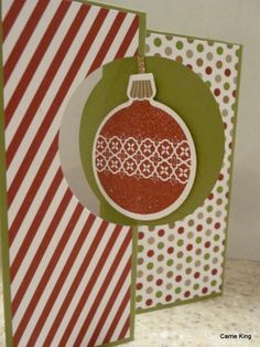 an ornament is hanging from the side of a christmas card with red and green stripes