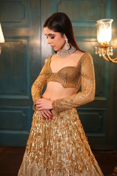 Ombre gold and silver bridal lehenga embellished with sequin, crystals, beads, cutdana embroidery, and a matching full-sleeved blouse in gold. The lehenga comes with a shaded embroidered cutwork dupatta.DELIVERY TIMEPlease allow 8-12 weeks for your outfit to arrive.FABRIC DETAILSNetProfessional cleaning only. Designer Gold Lehenga With Sequins, Silver Bridal Lehenga, Festive Gold Lehenga With Cutdana Details, Gold Embellished Lehenga, Gold Embellished Semi-stitched Lehenga, Metallic Gold Lehenga, Lehenga Gold, Silver Lehenga, Cutdana Embroidery