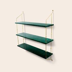 three green shelves with gold bars on each shelf, one is empty and the other has two