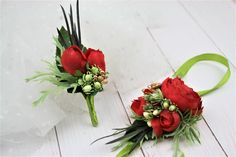 two red roses and greenery are sitting on the floor next to each other,