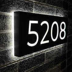 a close up of a light on a brick wall with the number 52208