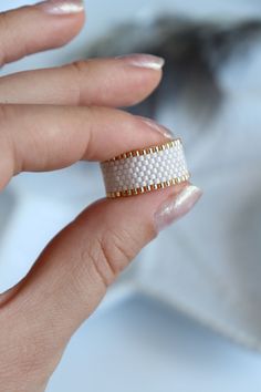 a woman's hand with two rings on her fingers and one ring in the middle