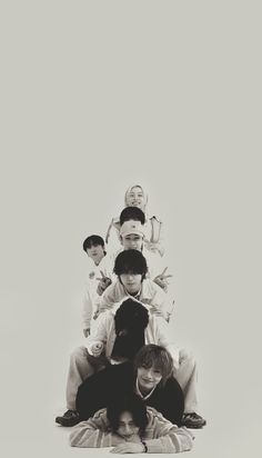 black and white photograph of five boys sitting on top of each other with their heads together