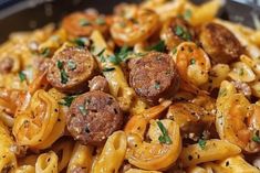 pasta with sausage, tomatoes and onions in a skillet ready to be eaten or served