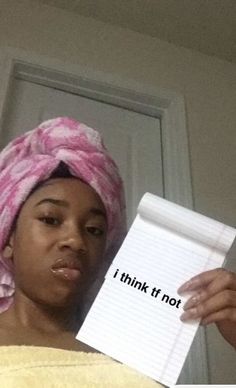 a woman with a towel on her head holding a piece of paper that says i think it's not