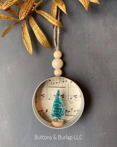 an ornament with a christmas tree on it and music notes in the background