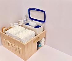 a wooden box filled with lots of items on top of a white floor next to a wall