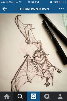 a drawing of a bat on paper next to two markers