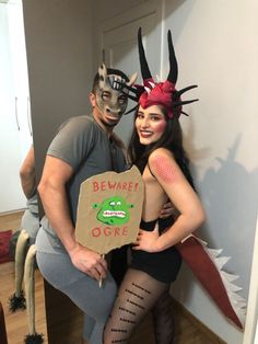 a man and woman dressed up in costumes pose for the camera while holding a cardboard box