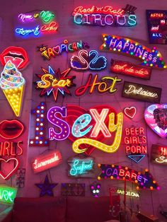 various neon signs are displayed on the wall