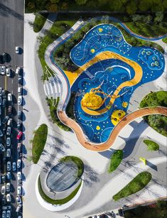 an aerial view of a blue and yellow pool in the middle of a parking lot