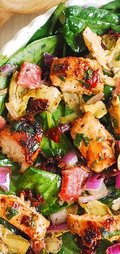 a white plate topped with meat and veggies on top of a wooden table