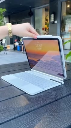 an open laptop computer sitting on top of a wooden table