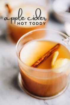 an apple cider in a glass with cinnamon stick garnish