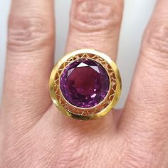 A fabulous vintage dress ring featuring a large, round, synthetic Alexandrite bezel set and mounted in a heavy 18ct yellow gold mount with a sun ray pattern border. A bold and beautiful ring, perfect for those who love colourful statement jewellery. Circa 1950-1960. With a partial stamp for 18ct gold. The width of the head measures approximately 19.4mm (at the widest point). The depth of the setting (height off the finger) measures approximately 8.9mm. The approximate weight is 7.5 grams. Please note the antique ring box pictured is for display purposes only. Thank you. Ring size N ½ (UK) or 6 ¾ (US) - this ring can be adjusted in size in our workshop. Please get in touch to discuss sizing options and lead time. For UK to US ring size conversions we use www.ringsizes.co as our reference ch Antique Ring Box, Contemporary Jewelry Design, Portfolio Ideas, Traditional Diamond, Statement Jewellery, Bold And Beautiful, Dress Rings, Beautiful Ring, Contemporary Jewelry