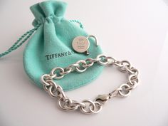 Offered for sale is a wonderful and very elegant Tiffany and Co. Sterling Silver 1837 Round Padlock Charm bracelet. The piece is made from substantial and bright Tiffany silver, and yet retains a very feminine feel to it. Attached to its very substantial Tiffany Silver charm bracelet is a fantastic and classic Tiffany 1837 Round Padlock charm. The padlock charm opens and closes and can thus be used on another necklace or charm bracelet - if you choose to do so. Super versatile piece! It is a cla Luxury Chain Bracelet With Box Clasp For Formal Events, Luxury Chain Bracelet With Box Clasp For Formal Occasions, Luxury Engraved Chain Bracelet For Formal Occasions, Luxury Chain Bracelet With Sterling Silver Clasp As Gift, Designer Bracelets With Polished Finish For Gift, Designer Polished Finish Bracelets For Gift, Elegant Formal Chain Bracelet, Luxury Polished Chain Bracelet Gift, Luxury Polished Chain Bracelet As Gift