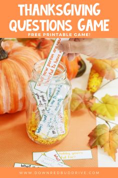 a jar filled with candy sitting on top of a table next to pumpkins and leaves