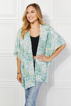 A stunning fashion piece that effortlessly combines elegance, comfort, and a touch of playfulness. This kimono is designed to make a statement and elevate your wardrobe to new heights of style. The colors burst with life, creating a mesmerizing visual effect that is sure to turn heads wherever you go. The soft, flowing fabric drapes gracefully over your body, exuding an air of sophistication and grace. What sets this kimono apart is the exquisite ruffle side detail. The delicate ruffles cascade down the sides, adding a touch of whimsy and femininity to the design. Pattern type: Floral Style: Casual, Chic Features: Ruffle Neckline: Open front Length: Long Sleeve length: Short sleeves Sleeve type: Dolman sleeves Sheer: Yes Material composition: 100% polyester Stretch: No stretch Care instruc Spring Floral Print Outerwear For Loungewear, Oversized V-neck Spring Cover-up, Spring Flowy Wrap Cover-up, Flowy V-neck Kimono For Day Out, Spring Loungewear Tops With Kimono Sleeves, Flowy Spring Loungewear Cover-up, Oversized Spring Cover-up For A Day Out, Chic Summer Outerwear For Loungewear, Flowy Open Front Top For Spring