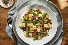 a white plate topped with potatoes and asparagus on top of a wooden table