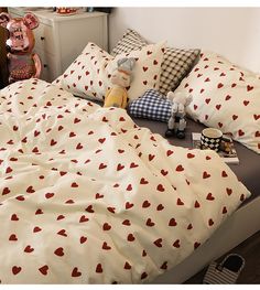 an unmade bed with hearts on it