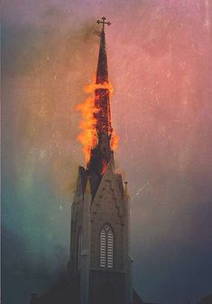 a church steeple with flames coming out of it's sides and the sky in the background