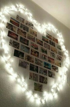 a heart made out of photos is shown with string lights on the wall above it