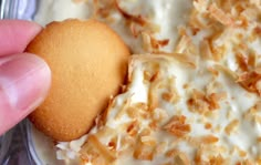 a close up of a person holding a piece of food with icing on it