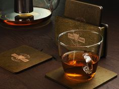 a cup of tea sitting on top of a wooden table next to two coasters