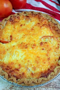 a pie sitting on top of a table next to tomatoes