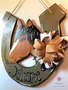 a metal sign with a horse on it that says welcome