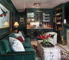 a living room filled with furniture next to a fire place under a painting on the wall