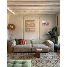 a living room with couches, tables and rugs on the carpeted floor