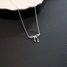 Add a sweet touch to your jewelry collection with our Small Bow Necklace. Delicate and stylish, this necklace is the perfect for everyday wear or special occasions, effortlessly enhancing any outfit. * Design: Features a dainty bow, symbolizing elegance and playfulness. * Material: High-quality 925 Sterling silver. * Size: 1 mm Thick Cable Chain, Bow: 12x15 mm * Chain Length: 40cm + 4cm * Matching Bow Earrings: https://liorajewelryhouse.etsy.com/listing/1659586743 * Complimentary Gift Wrapping * Sterling Silver Clavicle Chain Necklace Suitable For Gifting, Elegant Silver Necklace For Gift, Delicate Sterling Silver Charm Necklace For Formal Occasions, Sterling Silver Clavicle Chain Charm Necklace For Formal Occasions, Elegant Round Charm Necklaces For Gifts, Elegant Round Charm Necklaces, Elegant Sterling Silver Necklaces For Gifts, Formal Sterling Silver Clavicle Chain Charm Necklace, Elegant Clavicle Chain Necklace For Gift