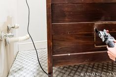 a person using a power drill to install a cabinet door