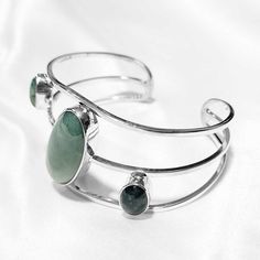 The Nova Bracelet is an elegant statement piece perfect for any occasion. Crafted as a silver cuff, this bracelet features three different jade colors for a stunning look. Perfect for adding a touch of class to your outfit. Middle - mint green jade (13x31mm) Sides - mint and blue/green jade (11x8mm) Sterling Silver (925) Silver Bracelets With Amazonite And Natural Stones, Silver Amazonite Bracelet As Gift, Silver Amazonite Bracelet For Gift, Elegant Amazonite Bracelets As A Gift, Elegant Green Cuff Bracelet For Formal Occasions, Elegant Cuff Bracelet With Natural Stones, Elegant Natural Stones Cuff Bangle Bracelet, Elegant Amazonite Gemstone Bracelets, Elegant Jewelry With Natural Stones And Chrysoprase