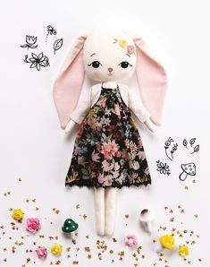 a stuffed animal wearing a dress next to flowers