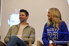 two people sitting on chairs in front of a projector screen