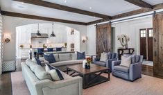 a living room filled with furniture and wooden beams