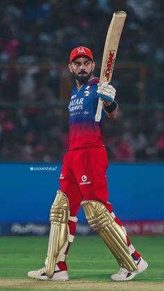 a man holding a cricket bat on top of a field