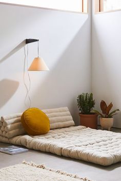 a bed that is sitting in the middle of a room with a lamp on it