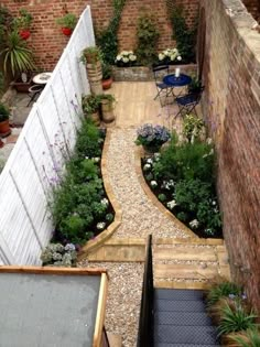 an outdoor garden with lots of plants and flowers on the side of the building, as seen from above