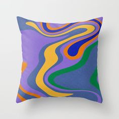 a pillow that is on top of a white wall with a blue, yellow and green design