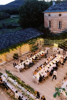 an aerial view of a wedding reception with string lights