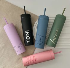 three personalized tumblers are sitting on a table next to a plate and napkin