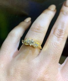 a close up of a person's hand wearing a ring with two diamonds on it