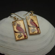 "Hand carved cloisonne bird cardinal earrings ( oiseau, vogel). One of our most popular birds, the Cardinal is the official state bird of no fewer than seven eastern states. Abundant in the Southeast, it has been extending its range northward for decades, and it now brightens winter days with its color and its whistled song as far north as southeastern Canada. Feeders stocked with sunflower seeds may have aided its northward spread. The cardinal bird is also known for representing celebration, r Elegant Bird Design Drop Earrings, Elegant Red Hand Painted Jewelry, Hand Painted Red Elegant Earrings, Elegant Hand Painted Red Earrings, Bird Design Enamel Jewelry Gift, Bird-shaped Jewelry Set With Matching Earrings, Gold Hand Painted Jewelry For Formal Occasions, Enamel Jewelry With Bird Design For Gifts, Cardinal Earrings