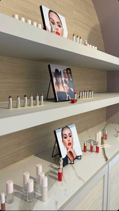 two shelves with pictures and candles on them in a beauty store, one is displaying the image of a woman's face