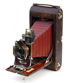 an old fashioned camera sitting on top of a wooden box