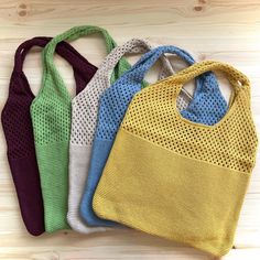 four different colored bags sitting on top of a wooden table