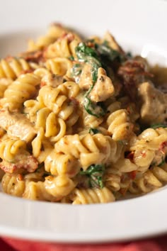 pasta with chicken and spinach in a white bowl